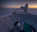 sun setting behind BICEP2 and the South Pole Telescope at Amundsen-Scott South Pole Station.